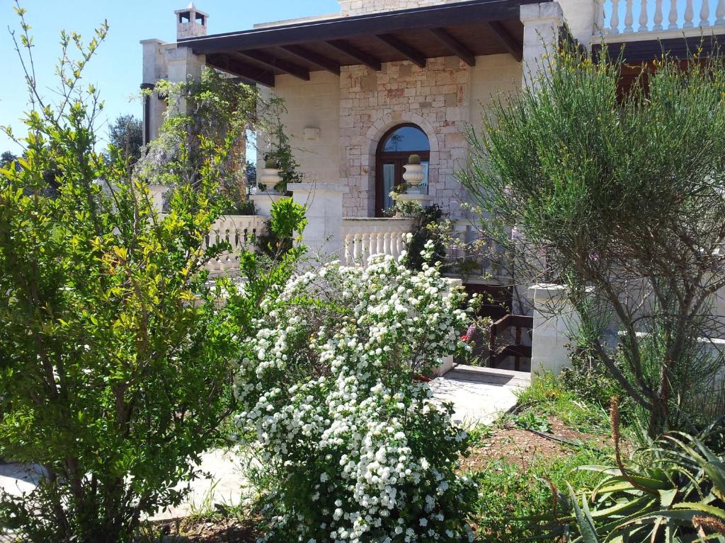 um jardim com flores brancas em frente a uma casa em Villa Pugliese em Savelletri di Fasano