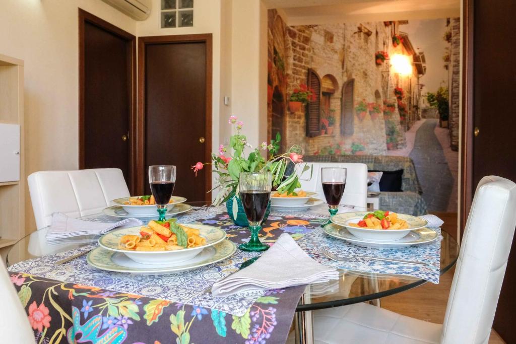 una mesa con platos de comida y copas de vino en Azzurra Home, en Roma