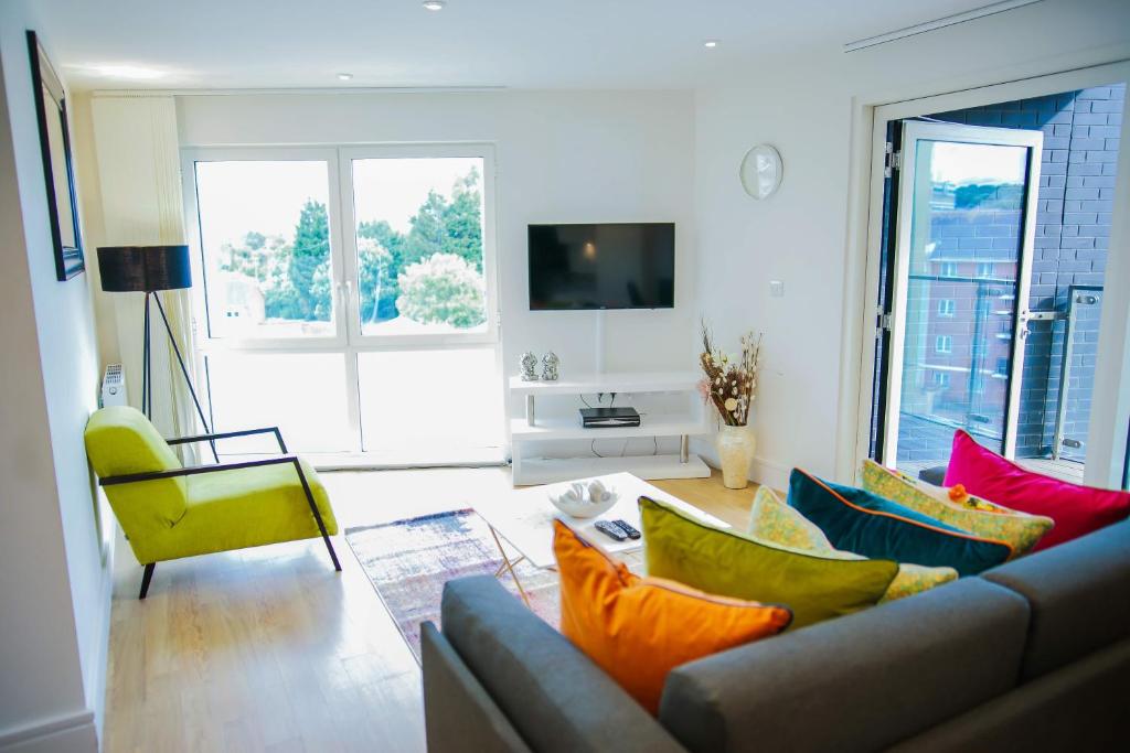 uma sala de estar com um sofá e almofadas coloridas em EXECUTIVE 2 BED APARTMENT em Londres