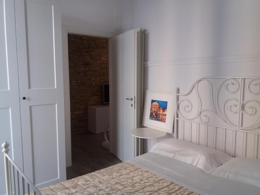 a white bedroom with a bed and a table at Dolce Dimora Charme in Lanciano