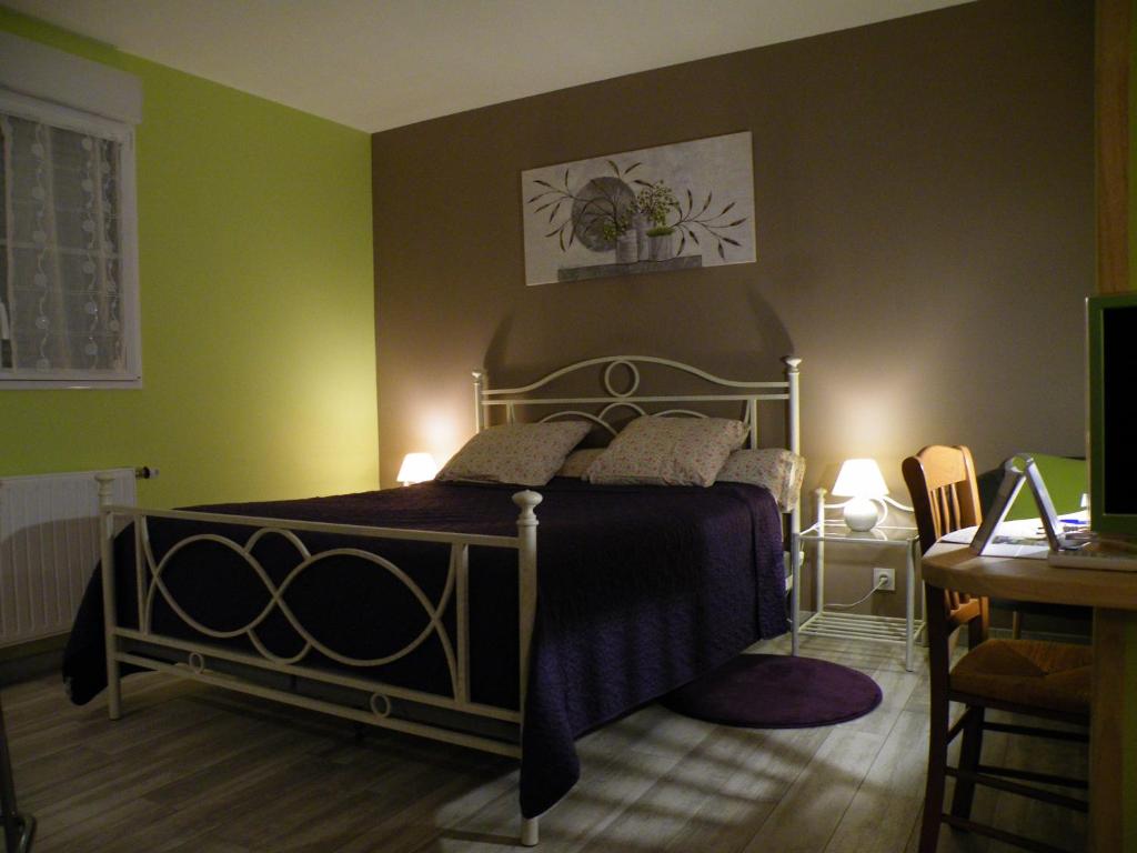 ein Schlafzimmer mit einem Bett in einem Zimmer mit grünen Wänden in der Unterkunft Les mouettes in Les Herbiers