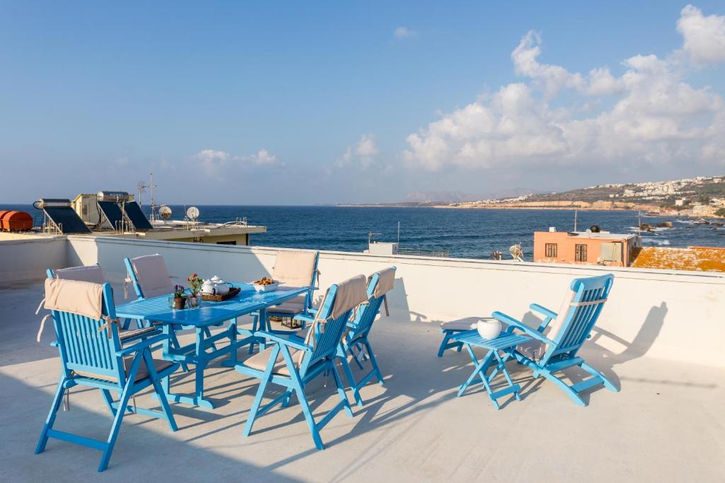 un tavolo blu e sedie su un balcone con vista sull'oceano di Sea View Penthouse with Roof Garden a Chania