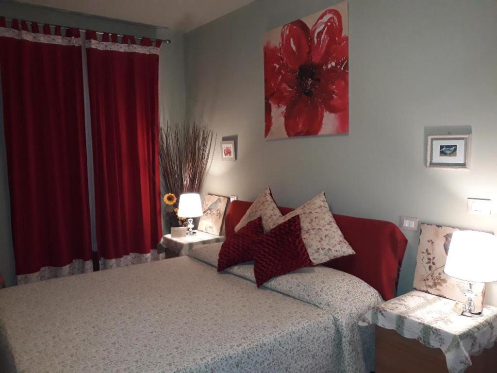 a bedroom with a bed and a red curtain at Anne's House in San Giuliano Terme