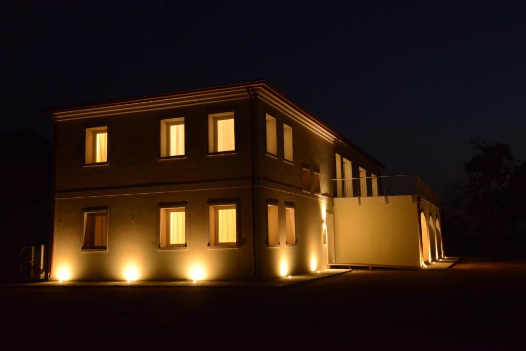 Una casa iluminada por la noche con luces encendidas en Ca' Vascon Alloggio Agrituristico en Villa Estense