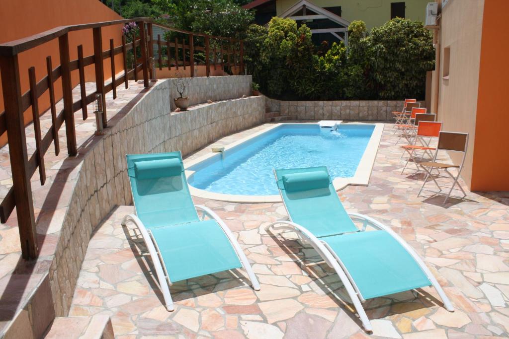 2 sedie a sdraio blu e una piscina di Kay Margo a Sainte-Luce