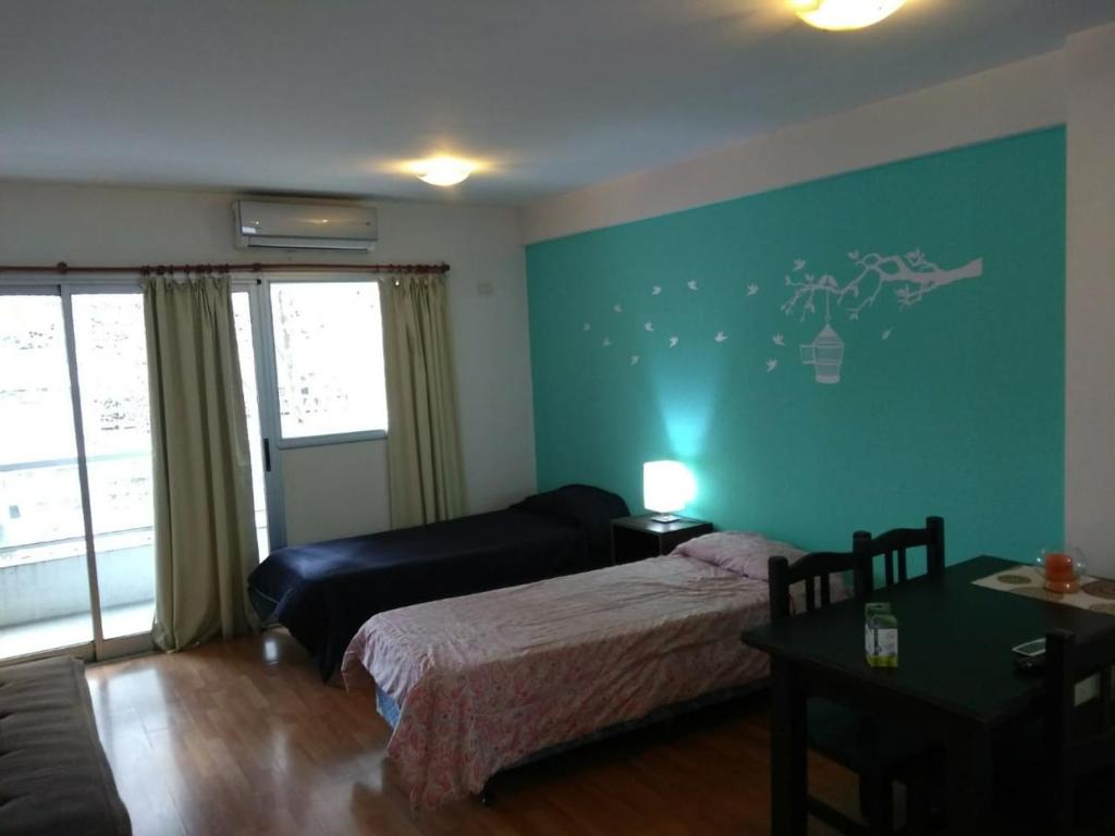 1 dormitorio con cama y pared azul en Depto36 Calle 44 entre 5 y 6 en La Plata