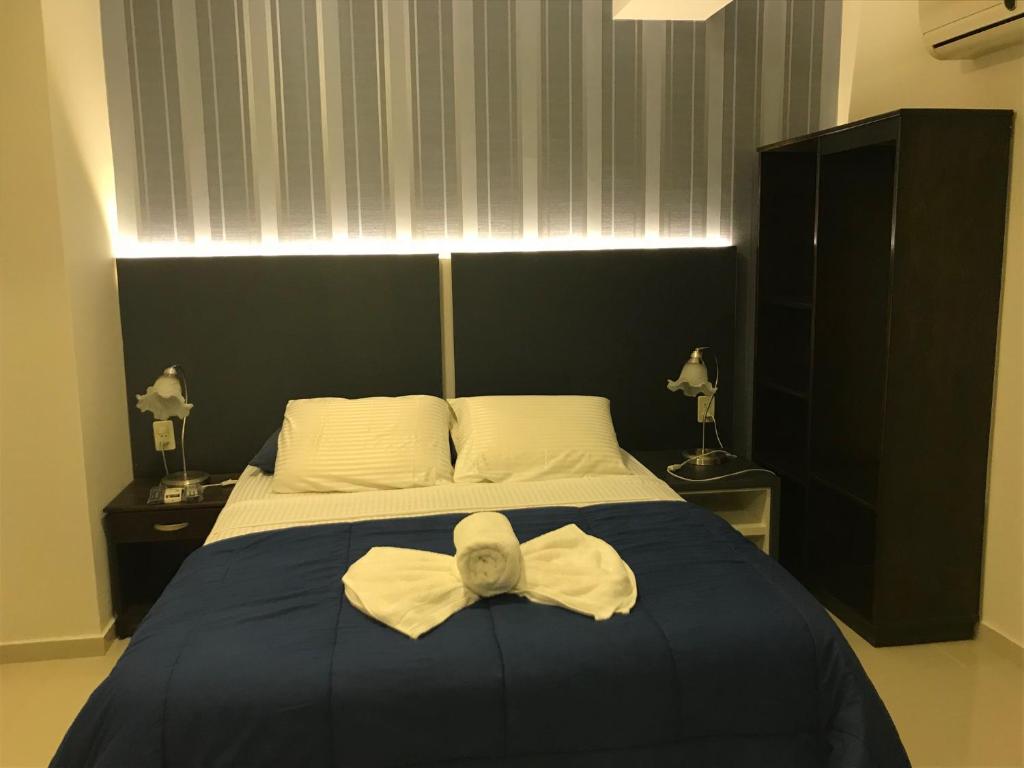 a bedroom with a bed with a bow on it at Del Rio Apart Hotel in Encarnación