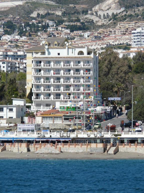 a large white hotel on the shore of the water at Sunny Beach in Benalmádena