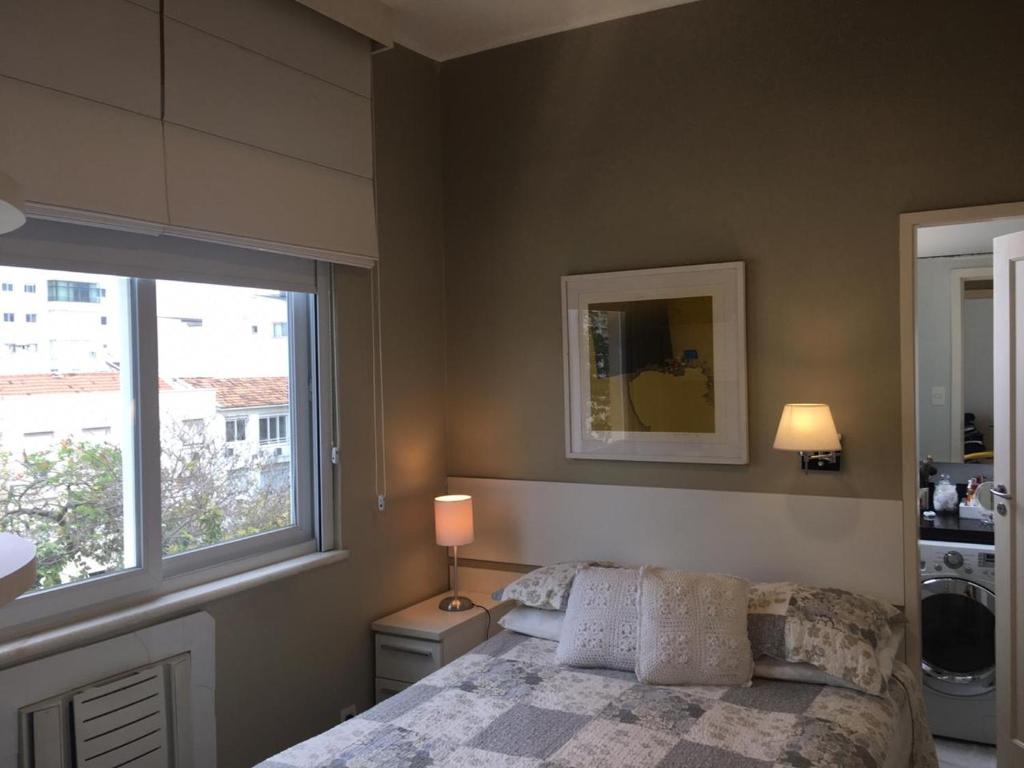 - une chambre avec un lit et une grande fenêtre dans l'établissement Ipanema Joa 510, à Rio de Janeiro