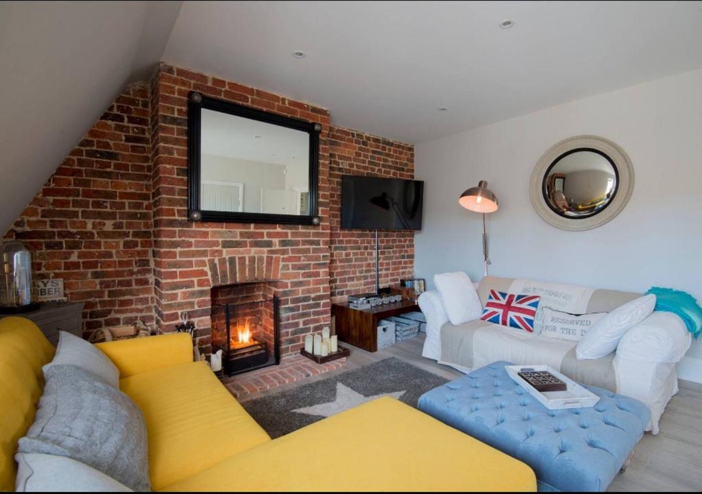 a living room with a couch and a brick wall at The Loft Midhurst in Midhurst
