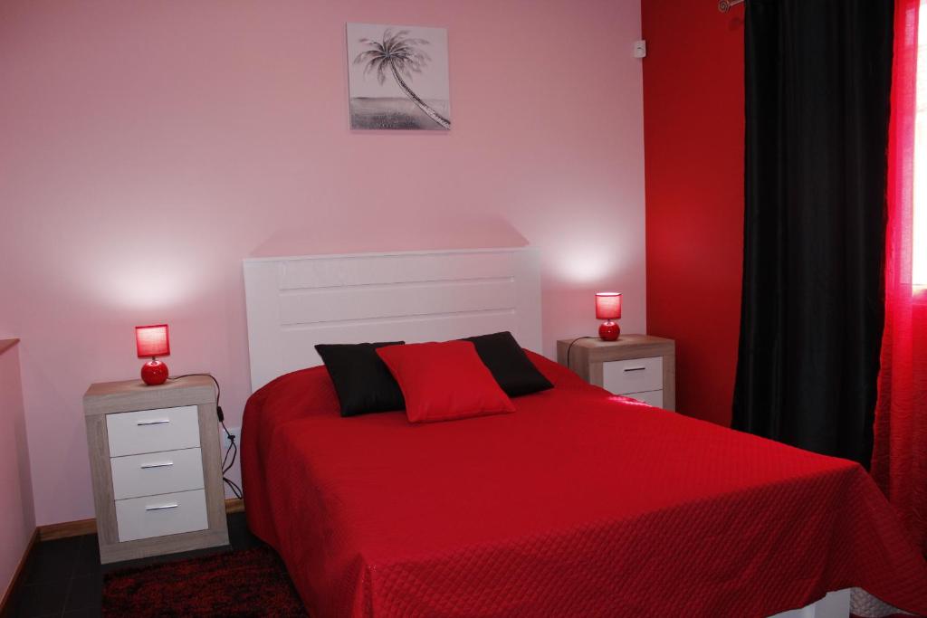 ヴィーラ・フランカ・ド・カンポにあるVila Centroのベッドルーム1室(赤いベッド1台、ナイトスタンド2台付)