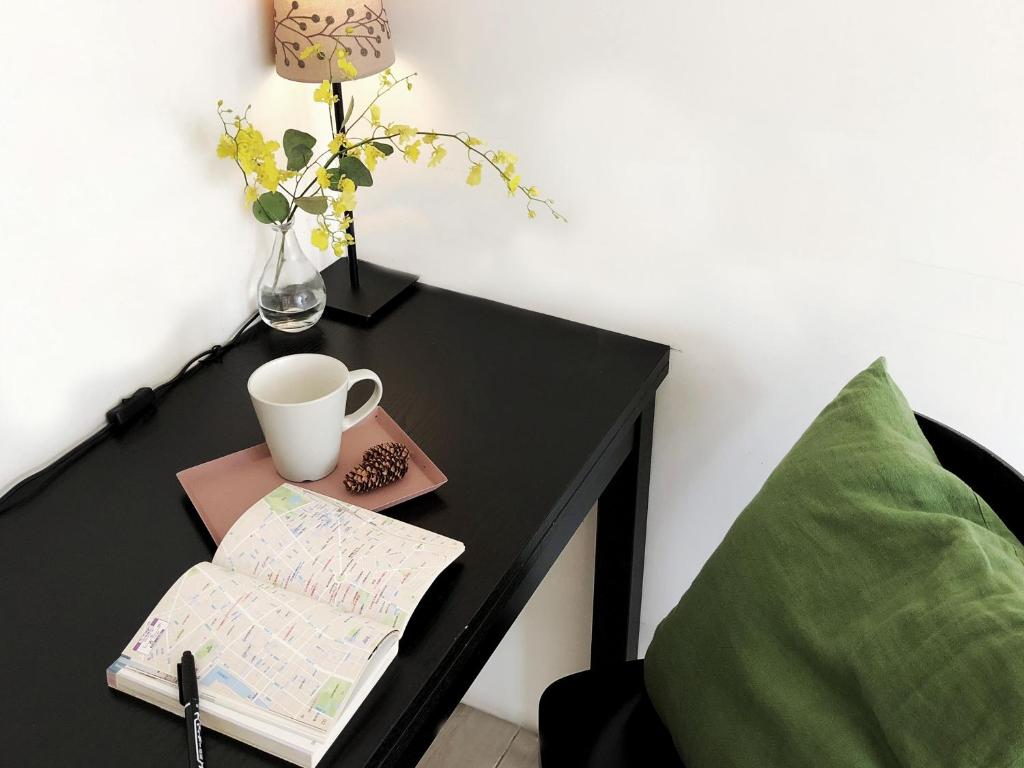 a black table with a map and a cup on it at Ahiruyah Guesthouse in Kaohsiung