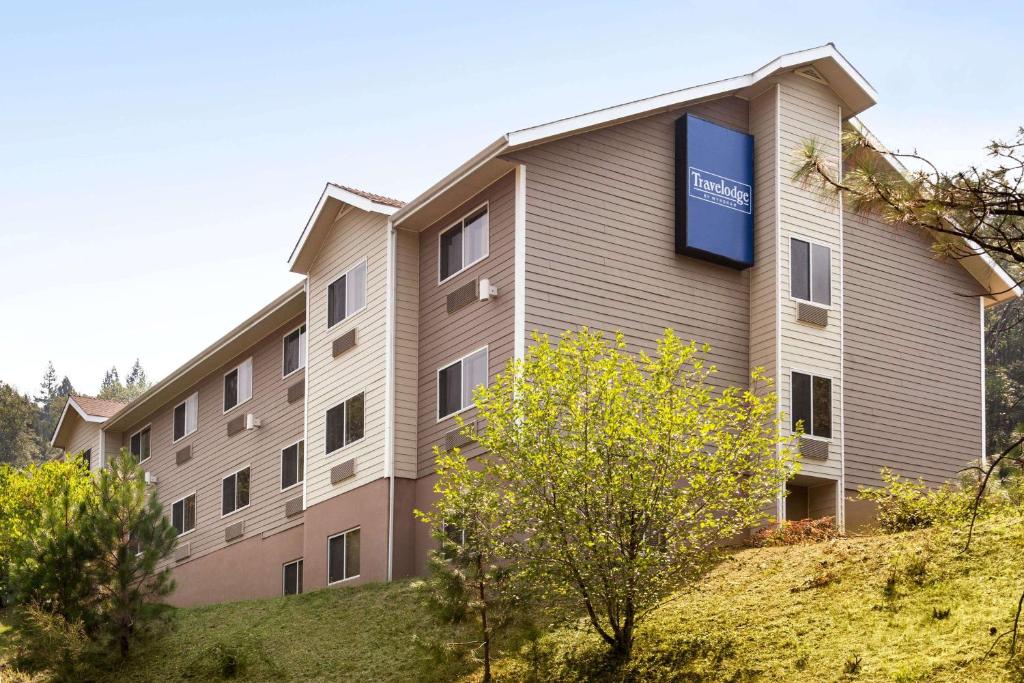 a building with a sign on the side of it at Travelodge by Wyndham Dunsmuir in Dunsmuir