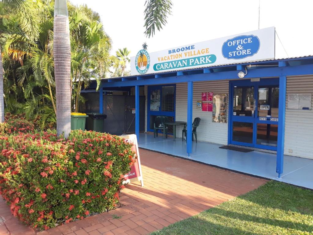 un edificio bianco e blu con un cartello sopra di Broome Vacation Village a Broome