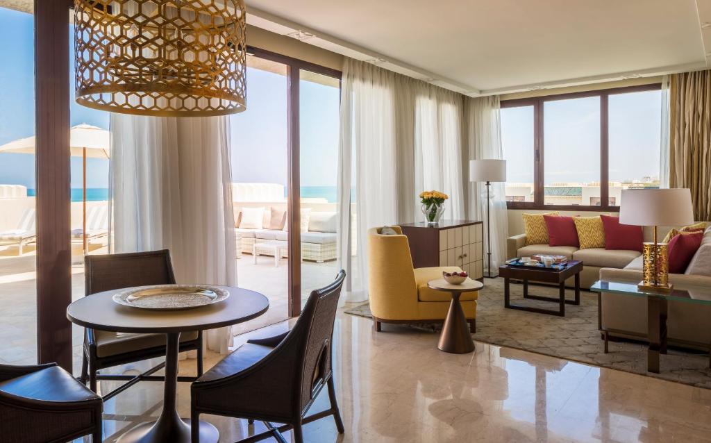 a living room with a table and chairs and a couch at Four Seasons Hotel Tunis in Gammarth