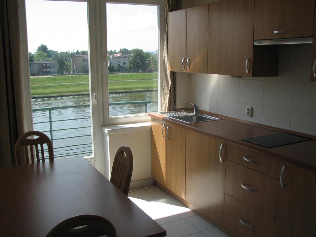cocina con mesa y vistas al agua en Salwator Apartments, en Cracovia