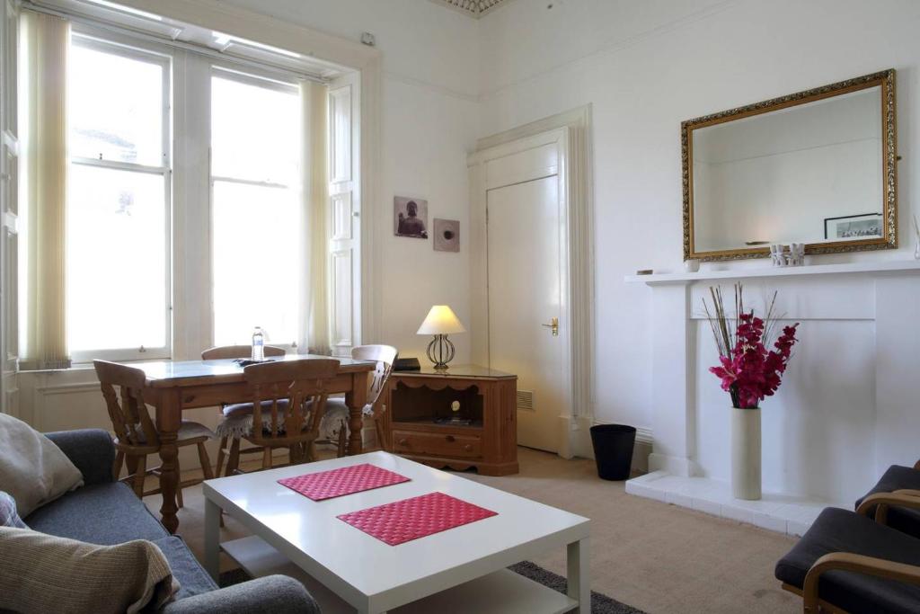 a living room with a table and a dining room at Grindlay Street Residence in Edinburgh