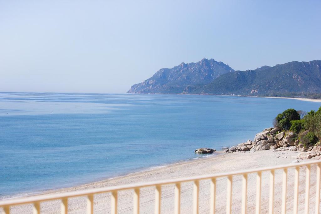 a beach with a fence next to the water at Due Mari Residence in Bari Sardo