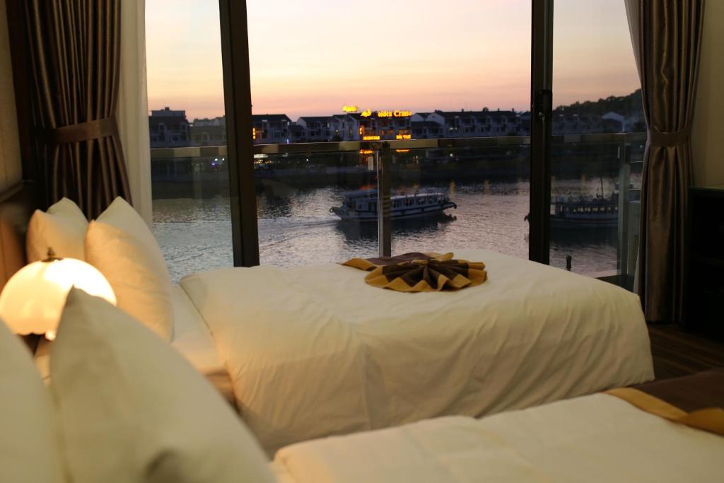 um quarto com uma cama e vista para a água em Moc Tra Hotel Tuan Chau Hạ Long em Ha Long