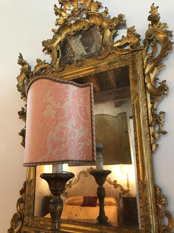 an ornate mirror with a lamp and a lampost at Luxury Venetian Rooms in Venice