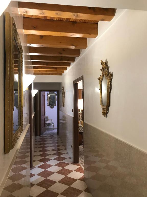 a hallway in a house with a checkered floor at Luxury Venetian Rooms in Venice