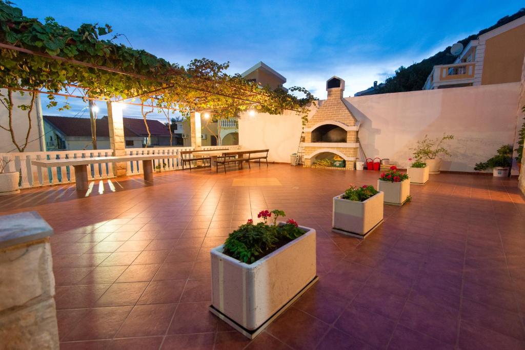 a patio with tables and potted plants on it at Vila Vukotić in Petrovac na Moru