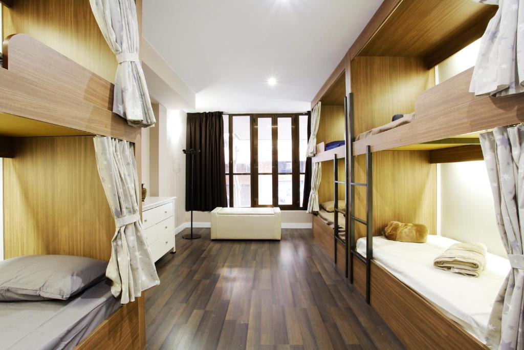 a dorm room with two bunk beds and wooden walls at Barcelona & You Hostel Sagrada Familia in Barcelona
