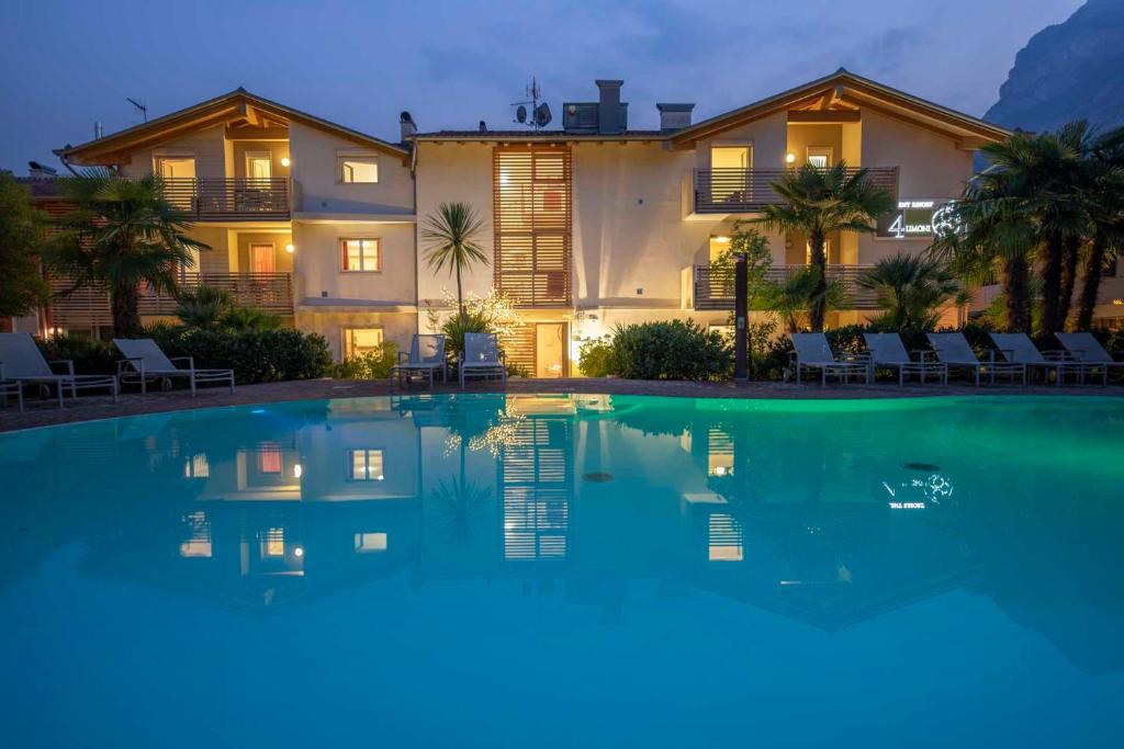 a large swimming pool in front of a house at 4 Limoni Apartment Resort in Riva del Garda