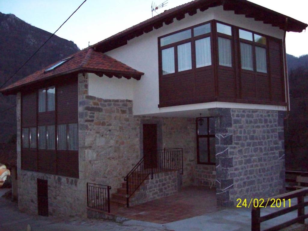una pequeña casa con balcón en la parte superior en Apartamentos rurales La Lastra 2 llaves, en Caso