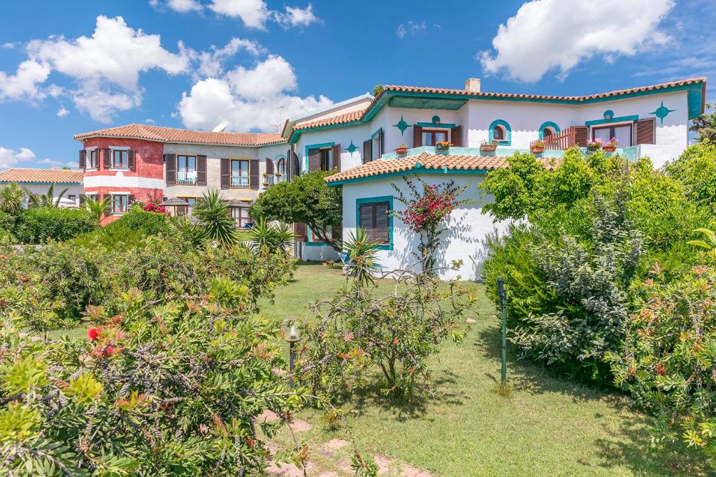 a large house with a garden in front of it at Hotel Stefania Boutique Hotel by the Beach in Olbia
