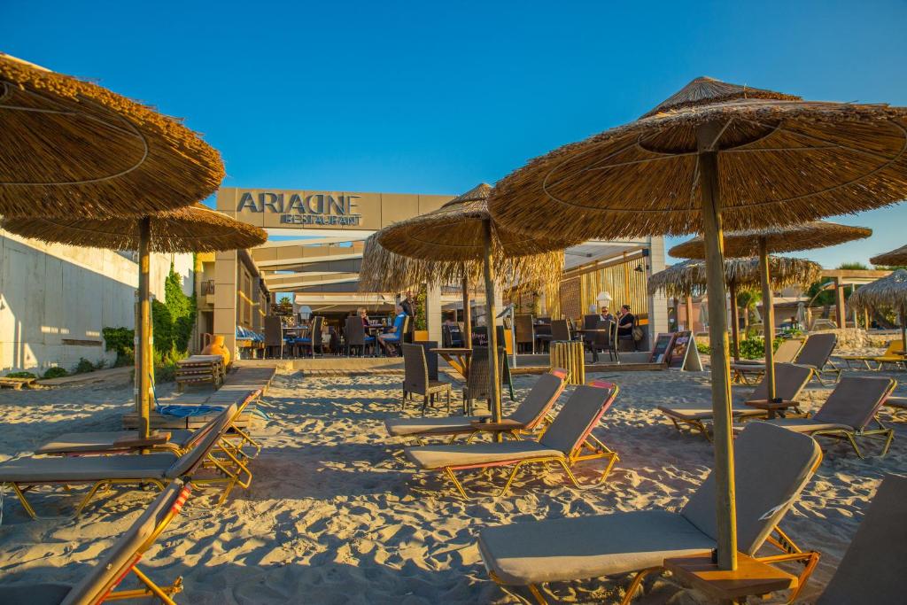 a group of chairs and umbrellas on a beach at Ariadne Beach in Platanias