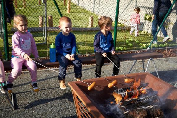 three young children playing with ropes around a fire at APARTMÁNY RYBNÍČEK in Staré Město