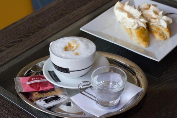 a tray with a cup of coffee and a plate of food at APARTMÁNY RYBNÍČEK in Staré Město