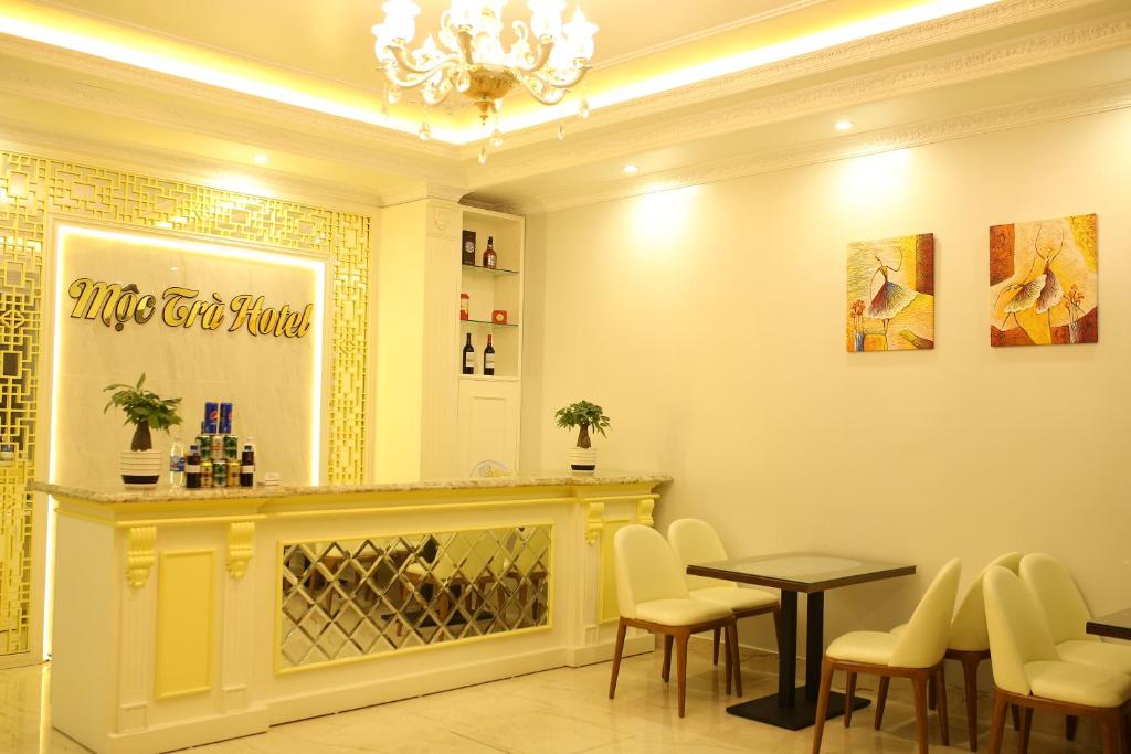 a restaurant with a bar with chairs and a table at Moc Tra Hotel Tuan Chau Hạ Long in Ha Long