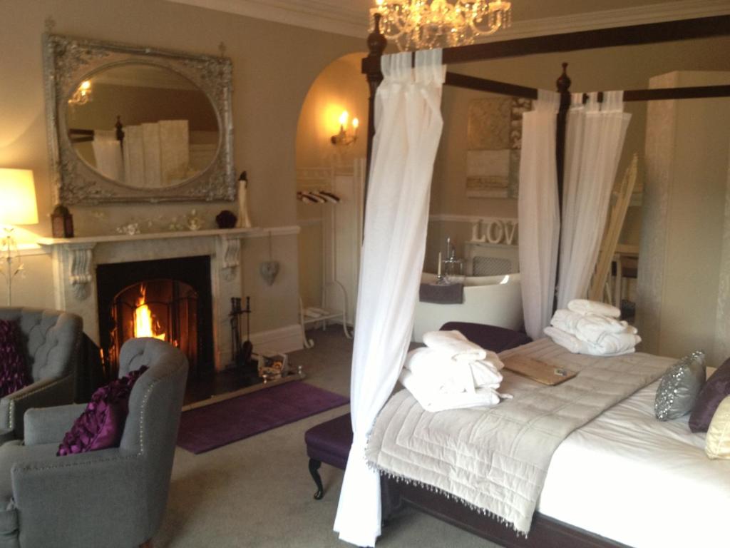 1 dormitorio con cama, chimenea y espejo en The Castle House, en Richmond