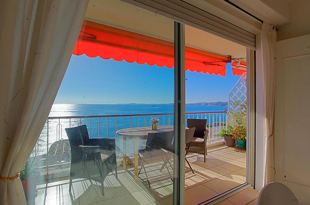 a balcony with a table and a view of the ocean at Cros De Cagnes in Cagnes-sur-Mer