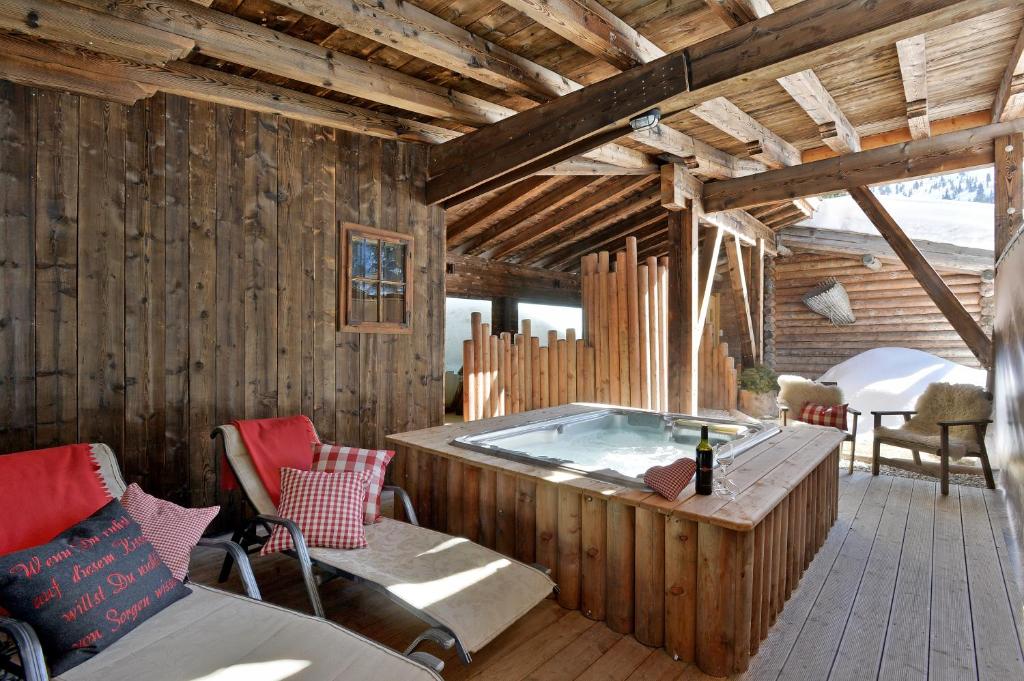 ホーホフューゲンにあるAlmnest in Hochfügen mit privat SPAの木造家屋内のホットタブ付きの部屋