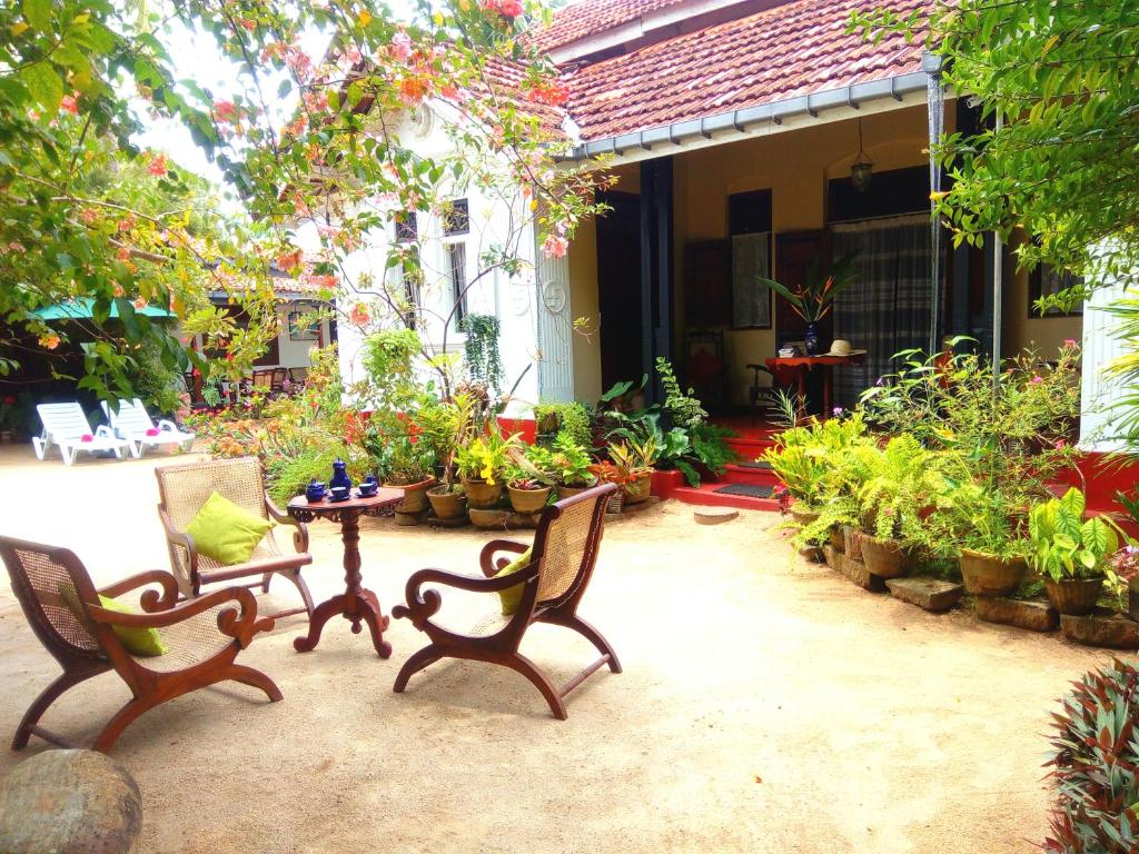 eine Terrasse mit Stühlen, einem Tisch und Pflanzen in der Unterkunft Walauwa The Villa Ahungalla in Ahungalla