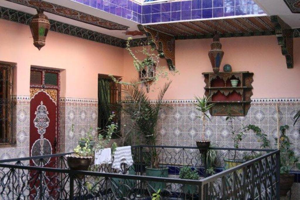 un edificio con un balcón con plantas. en Hotel Aday en Marrakech