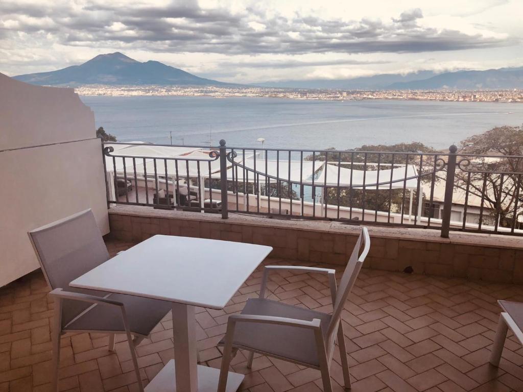 a table and chairs on a balcony with a view of the water at Hotel Elisabetta in Castellammare di Stabia
