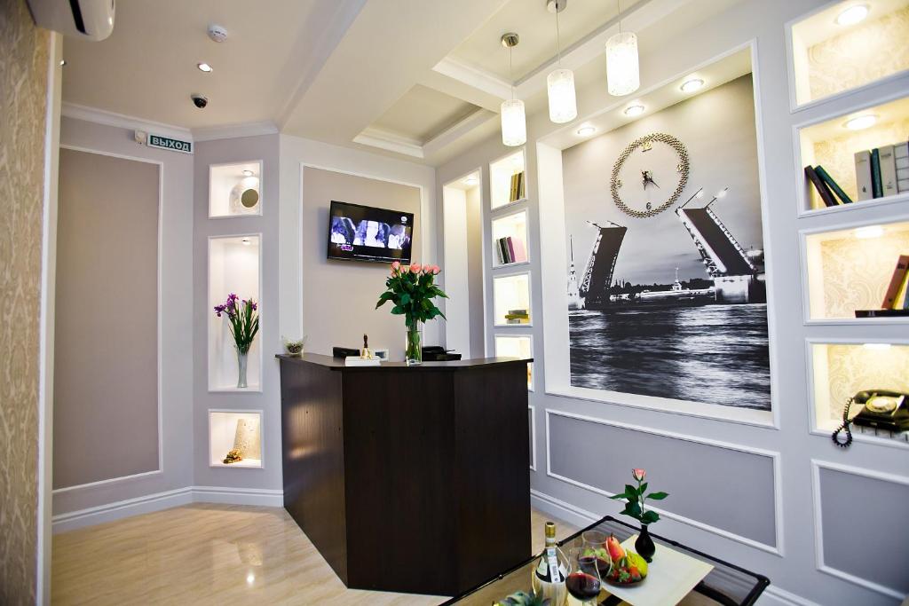 a lobby with a reception desk and a clock on the wall at Boutique Hotel Leningrad in Saint Petersburg