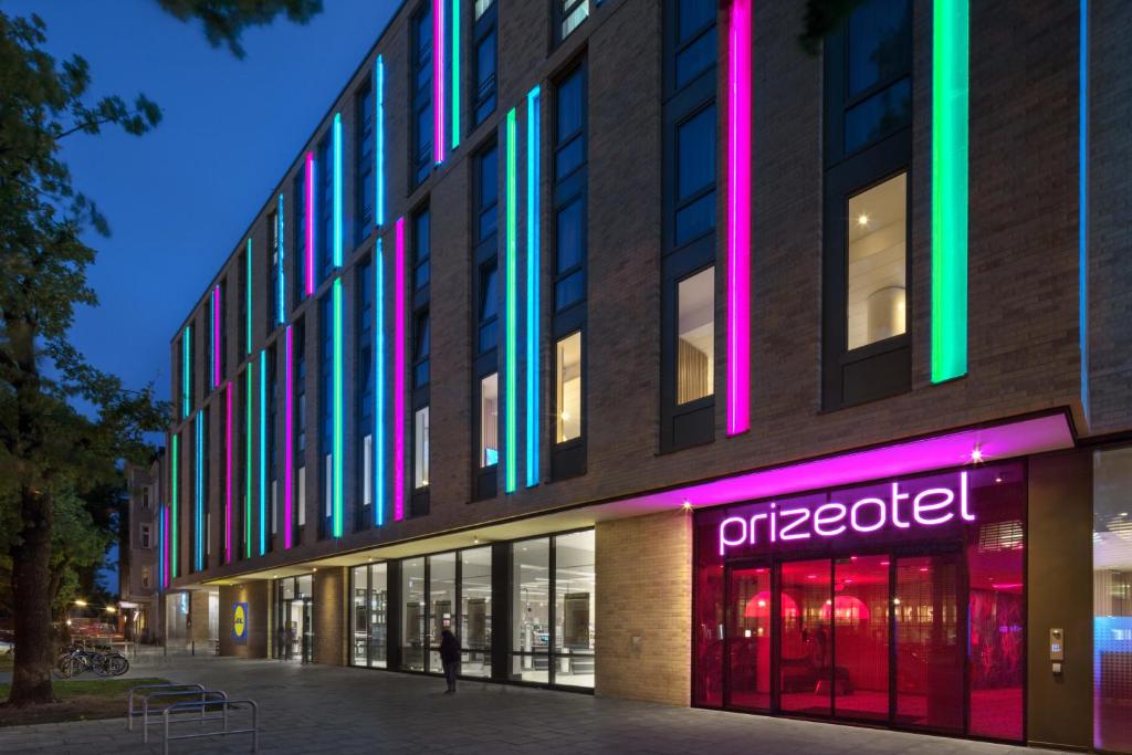 un edificio con luces de colores en el costado. en prizeotel Hamburg-St.Pauli, en Hamburgo