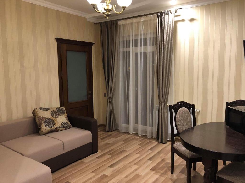 a living room with a couch and a table at cozy apartments in Truskavets