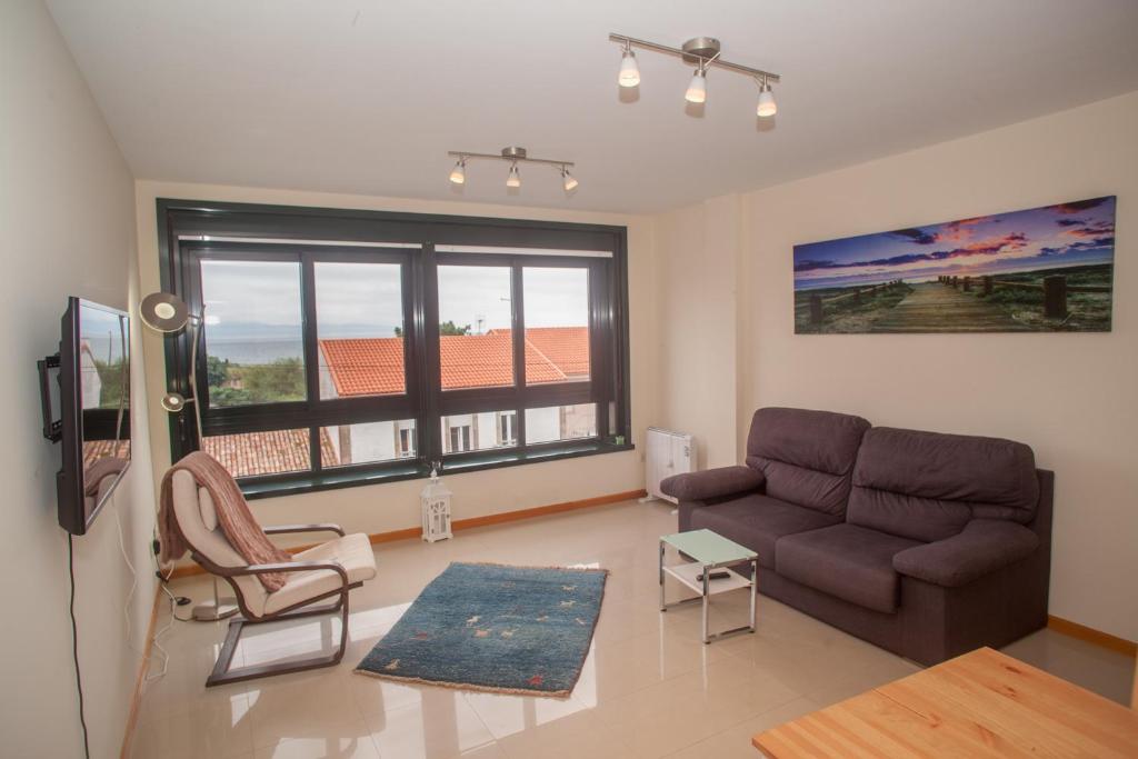 a living room with a couch and a tv at Beatiful holiday flat in Finisterre with sea views and next to the "Camino de Santiago" in Finisterre