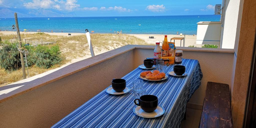 una mesa en un balcón con vistas a la playa en Casa Mimosa, en Alcamo Marina