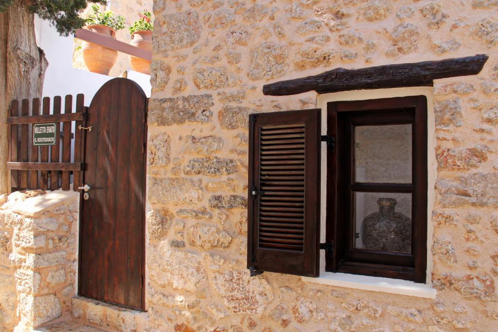 a window of a stone building with a man in it at Villetta Erato,picturesque studio in Chalki in Halki
