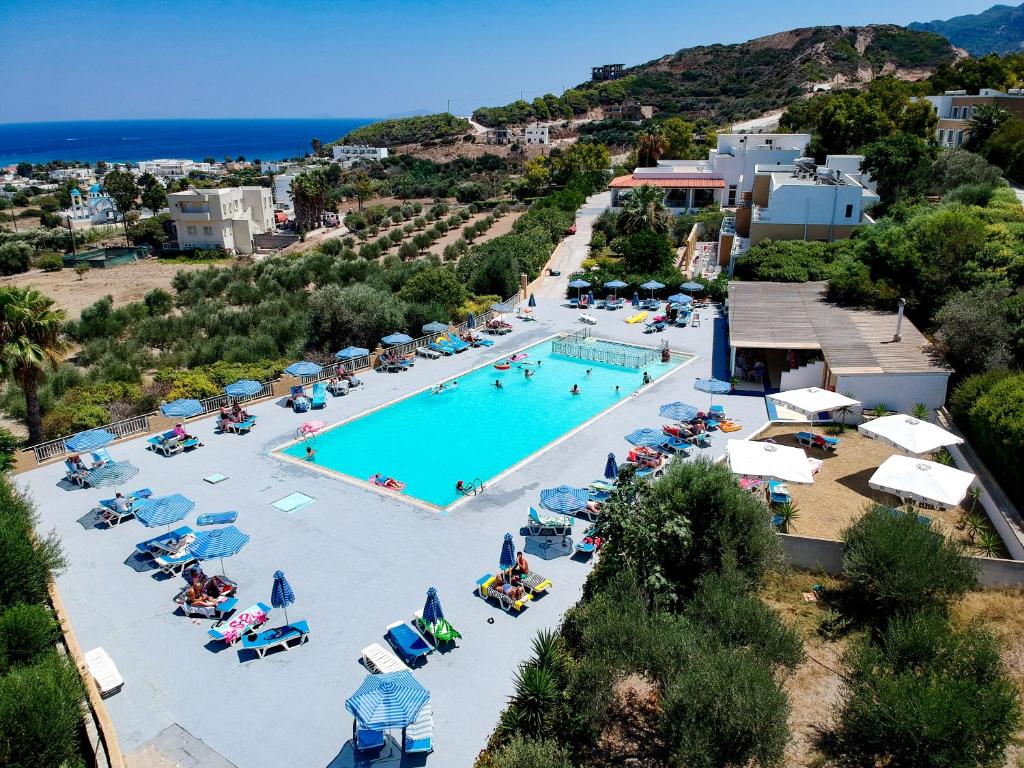 an aerial view of a pool with chairs and umbrellas at Hermes Hotel in Kefalos