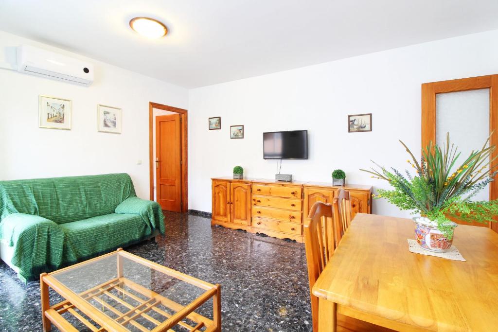 uma sala de estar com um sofá verde e uma mesa em Global Properties, Amplio apartamento muy cerca de la playa em Puerto de Sagunto
