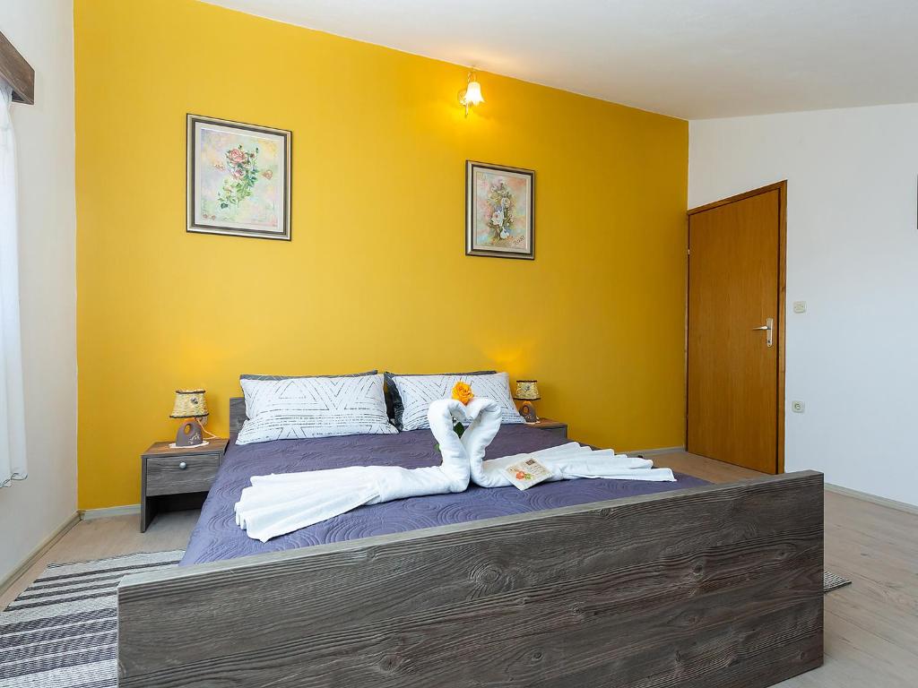 - une chambre avec un grand lit aux murs jaunes dans l'établissement Apartments Alice Green Oasis -, à Poreč