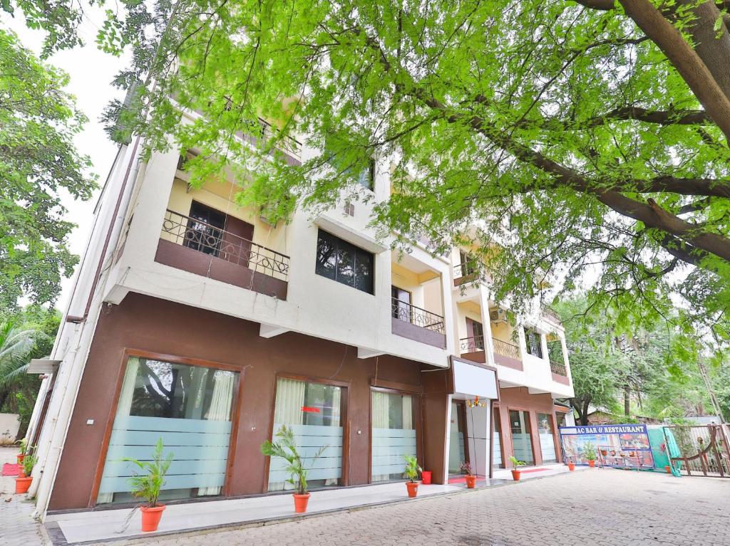 a building with a tree in front of it at Hotel Ambica in Daman